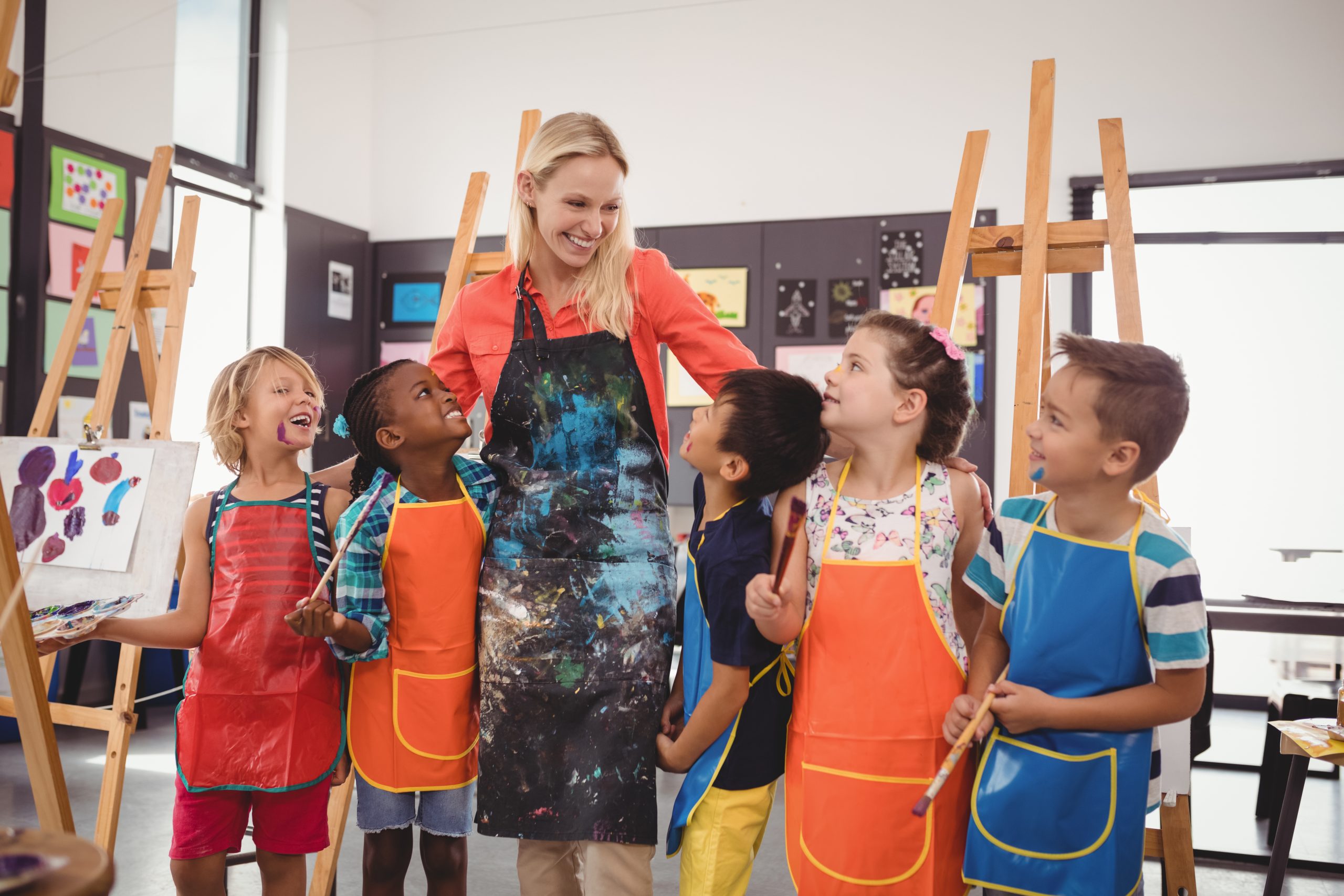 Teacher and schoolkids having fun in drawing class